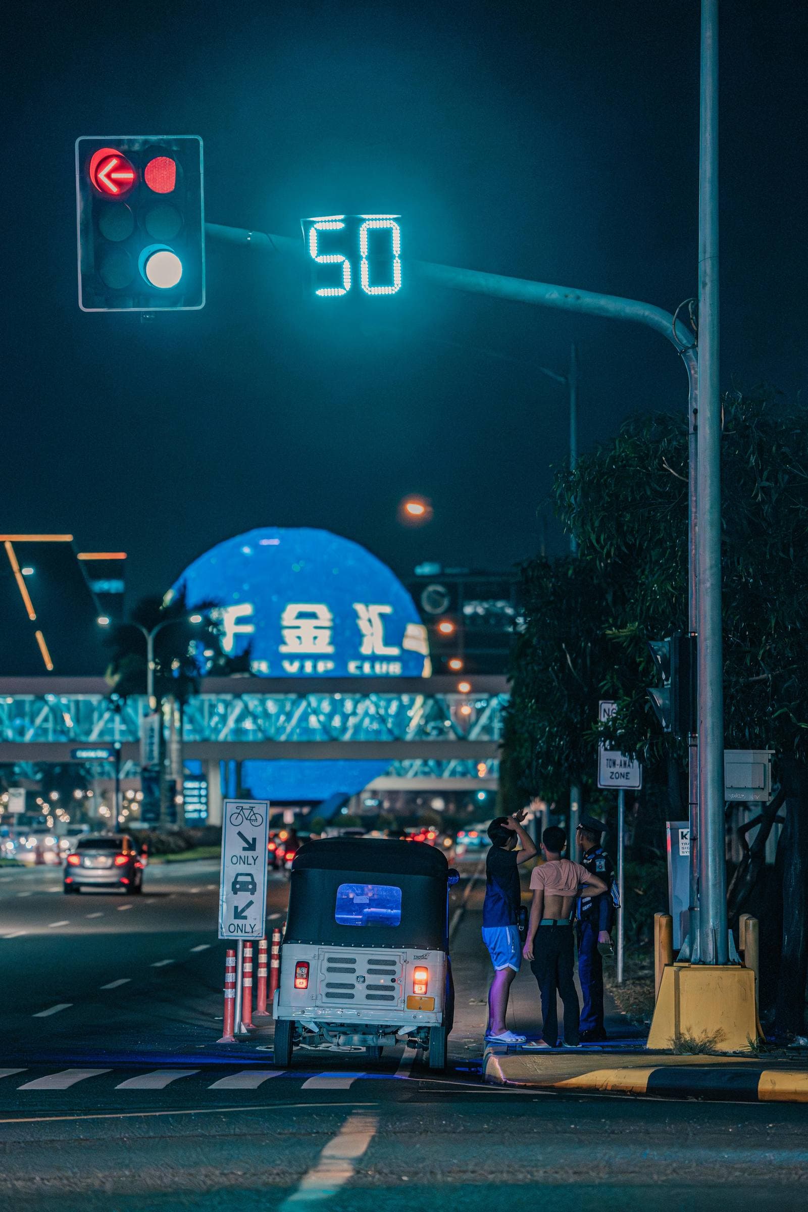 Stradă urbană aglomerată, cu trafic și clădiri înalte, într-un context rutier de seară.